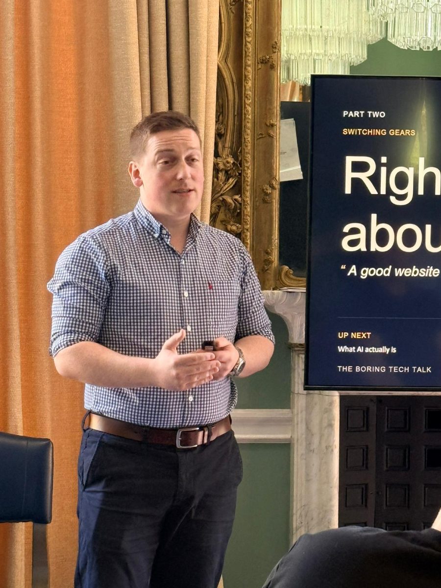 Sam gesturing beside the AI talk slide